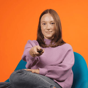 Girl holding a tv remote looking at tv