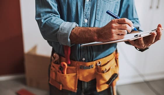 Contractor writing on a tablet