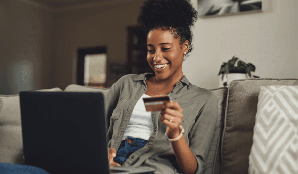 Woman typing in a credit card number on her computer